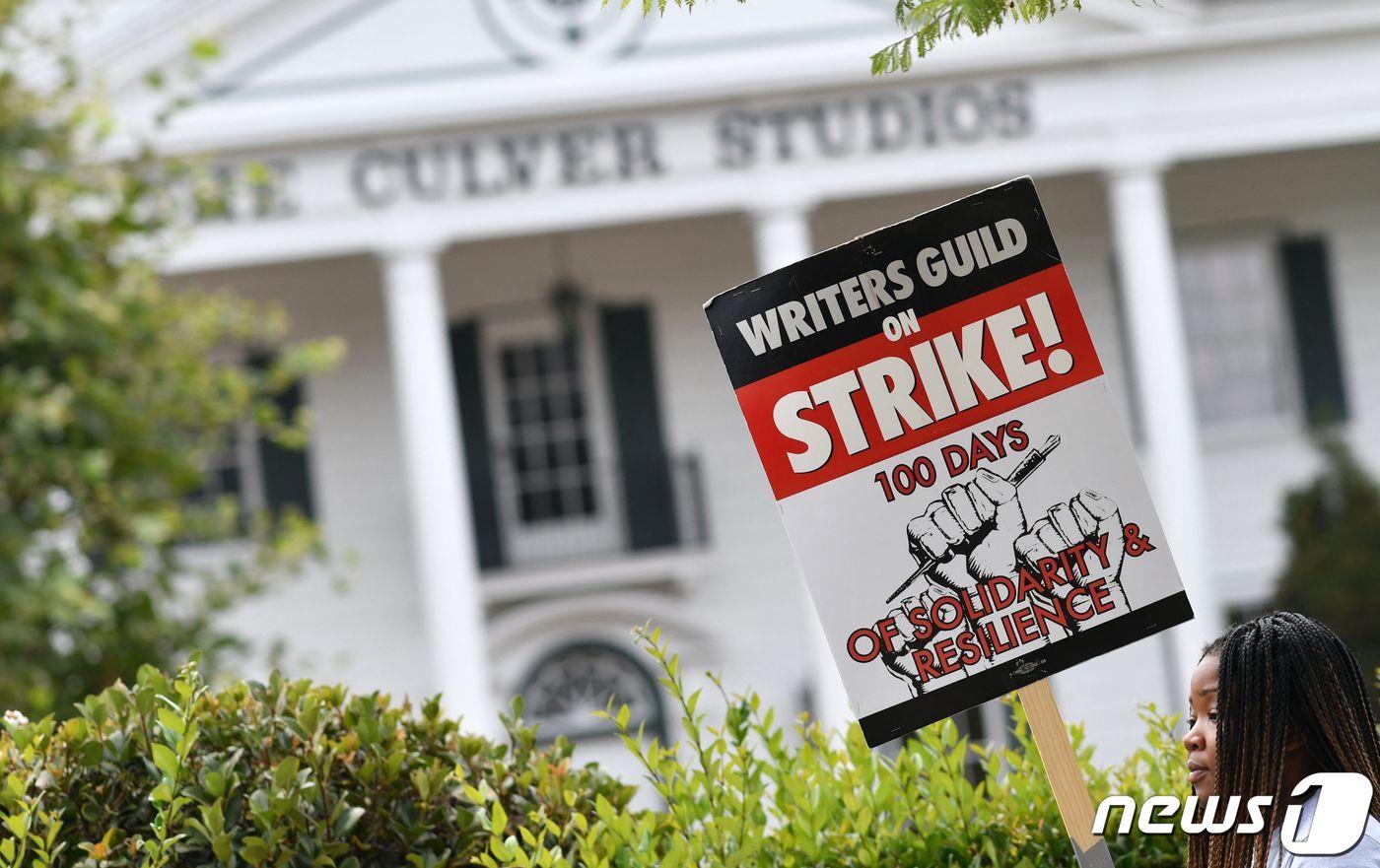 본문 이미지 - 9일(현지시간) 미국 캘리포니아 컬버시티 아마존 스튜디오 앞에서 한 미국작가조합(WGA) 회원이 피켓을 들고 있다. 처우 개선을 요구하는 할리우드 작가들의 파업은 이날로 100일째를 맞았다. 2023.08.10/ ⓒ AFP=뉴스1 ⓒ News1 김형준 기자