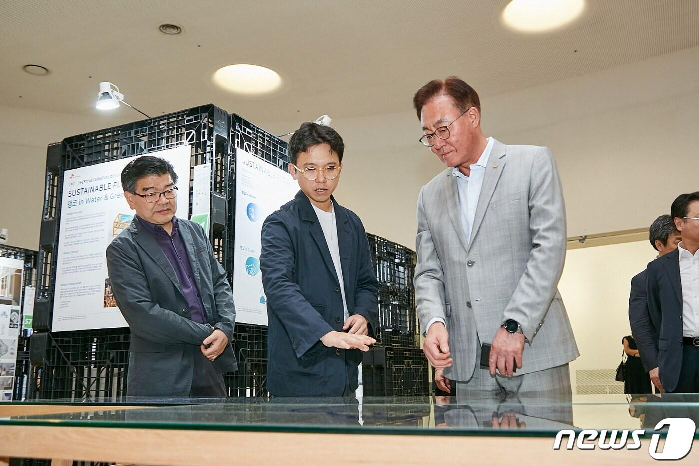 본문 이미지 - 김준 SK이노베이션 부회장이 SK이노베이션과 국민대학교가 서울 중구 동대문디자인플라자(DDP)에서 개최한 '행복그린디자인 전시회'를 방문해 학생 및 교수진과 작품에 대한 의견을 주고받고 있다.(SK이노베이션 제공)