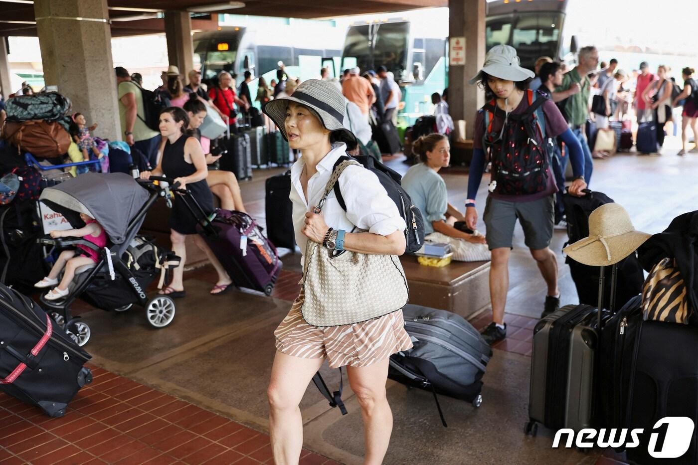 본문 이미지 - 10일(현지시간) 미국 하와이 마우이에서 산불로부터 대피한 이재민들이 짐을 챙겨 카훌루이 공항으로 들어서고 있다. 2023.08.11/ ⓒ 로이터=뉴스1 ⓒ News1 김형준 기자