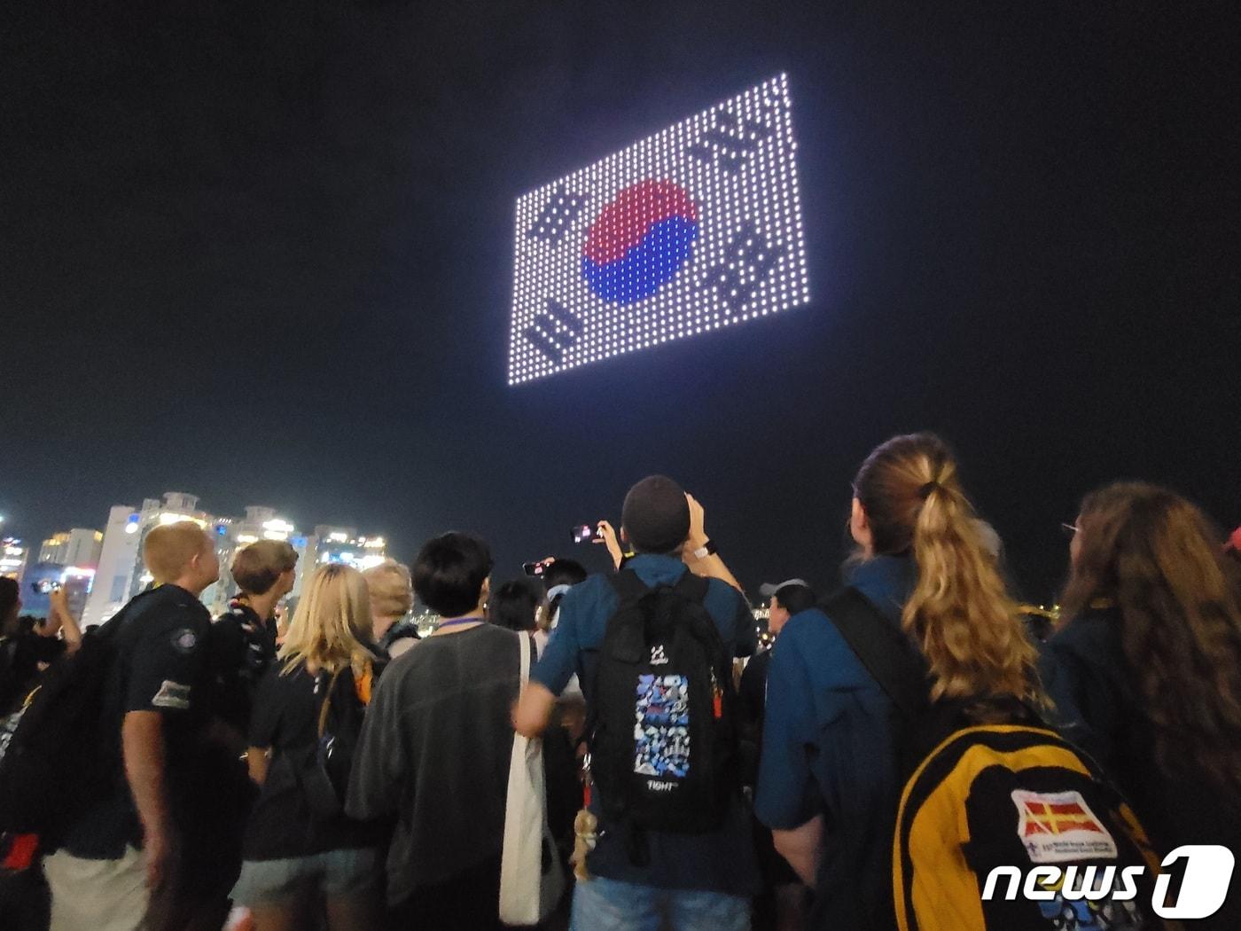 본문 이미지 - 12일 부산 수영구 광안리해수욕장을 찾은 잼버리 대원들이 광복절을 주제로하는 '드론 M 라이트쇼'를 보고 있다.2023.8.12/뉴스1 ⓒ News1 조아서 기자