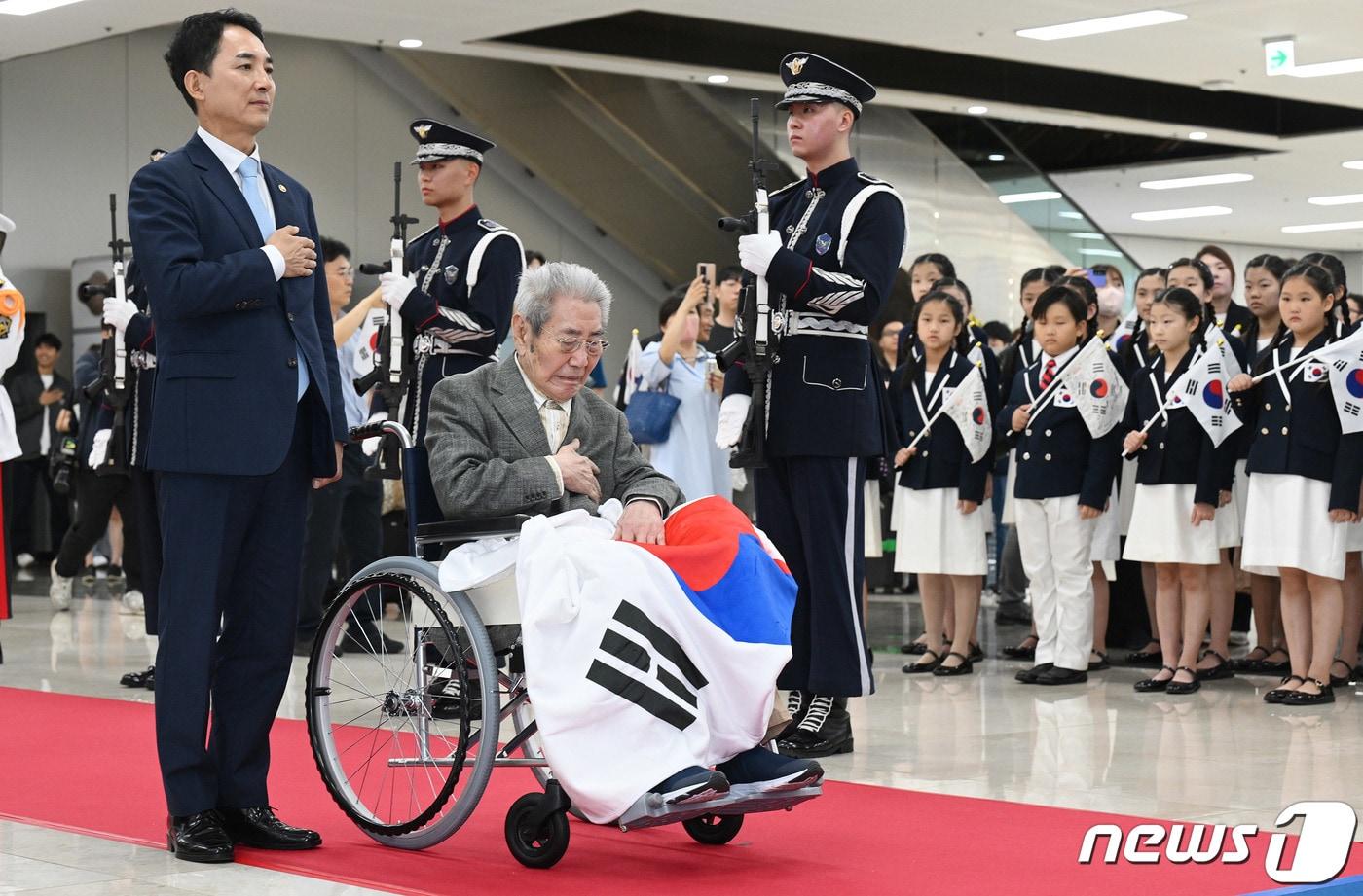 본문 이미지 - 오성규 애국지사(휠체어)가 지난 13일 서울 강서구 김포공항에서 열린 환국 환영행사에 참석, 박민식 국가보훈부 장관과 함께 국민의례를 하고 있다. . (공동취재) 2023.8.13/뉴스1 ⓒ News1 김도우 기자