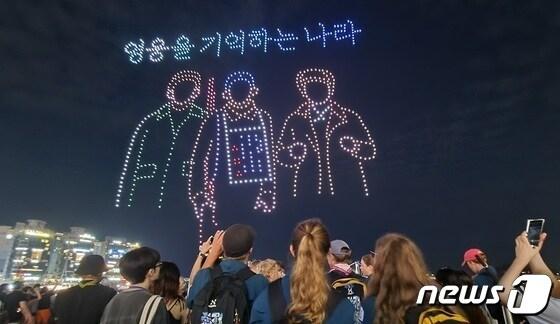 본문 이미지 - 12일 부산 수영구 광안리해수욕장을 찾은 잼버리 대원들이 광복절을 주제로하는 '드론 M 라이트쇼'를 보고 있다.2023.8.12/뉴스1 ⓒ News1 조아서 기자