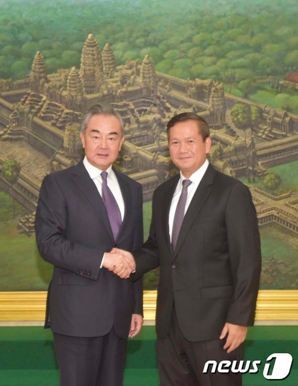 본문 이미지 - 왕이 중국 외교부장 겸 공산당 중앙정치국 위원이 13일 캄보디아 프놈펜에서 훈마넷 캄보디아 총리 지명자를 만나 악수를 나누고 있다. <출처=중국 외교부>