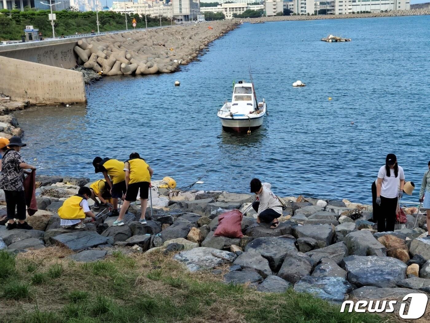 본문 이미지 - 지난 13일 부산 영도구 하리항에서 연안정화활동 '바다쓰담' 참여자들이 쓰레기를 수거하고 있다.(영도희망21 제공)