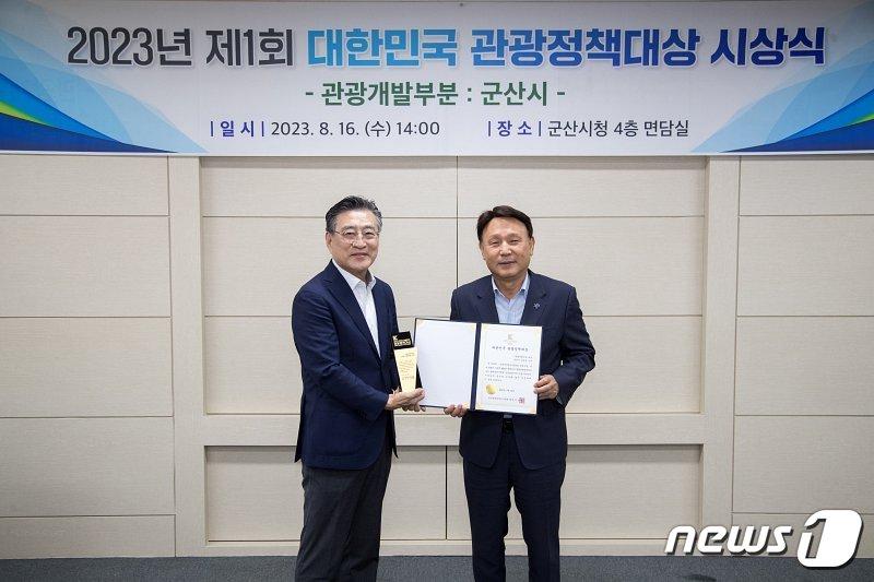 본문 이미지 - 강임준 군산시장(오른쪽)이 이연택 한국관광정책연구학회장으로부터 '대한민국 관광정책대상'을 수상하고 있다.(군산시 제공) 2023.8.16/뉴스1