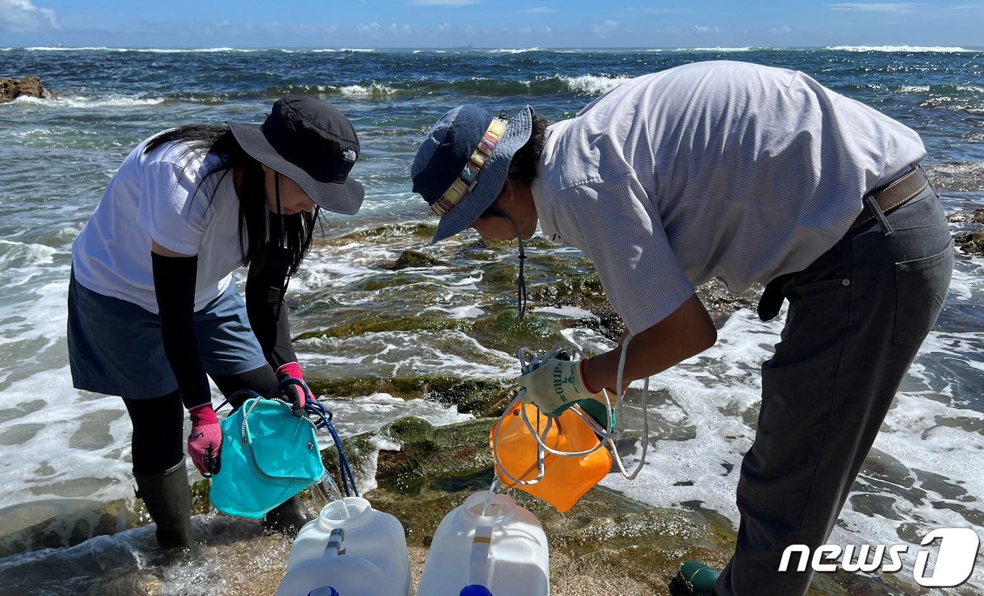 8일 일본 후쿠시마현(県) 이와키시(市) 해안가에서 비영리단체 '이와키 방사능 시민 측정실 타라치네' 소속 연구원들이 해수를 모아 통에 담고 있다. 2023.08.08/ ⓒ 로이터=뉴스1 ⓒ News1 권진영 기자
