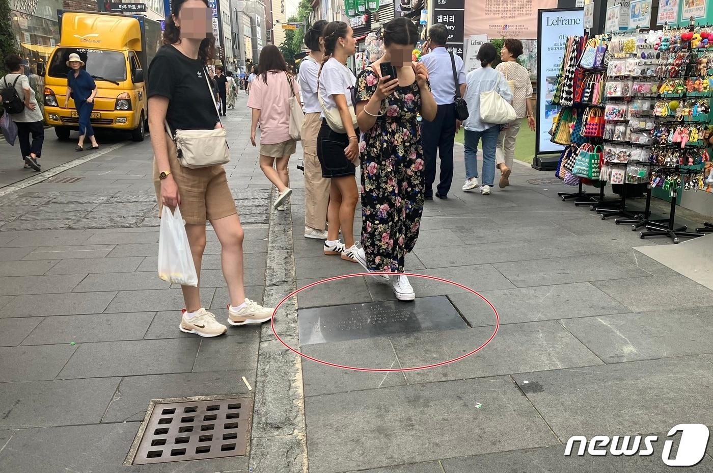 본문 이미지 - 인사동 '전통문화의거리'에서 한 관광객이 '한남서림' 표지판을 밟고 있다. 2023.8.13. ⓒ News1 김기성 기자