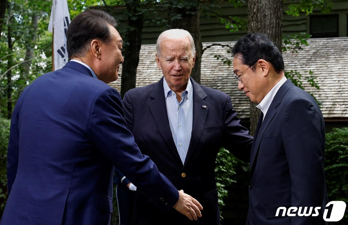 본문 이미지 - 윤석열 대통령과 조 바이든 미국 대통령, 기시다 후미오 일본 총리가 18일(현지시간) 미국 워싱턴DC 인근 대통령 별장인 캠프 데이비드에서 열린 한미일 정상회의에 앞서 인사를 나누고 있다. 2023.8.18 ⓒ로이터=뉴스1 ⓒ News1 오대일 기자