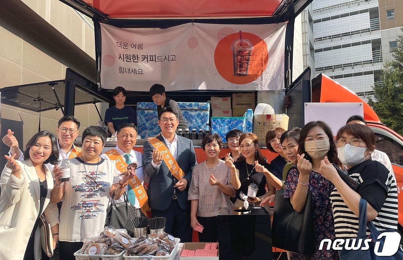 1일 한화생명금융서비스 의정부지역단의 지점장과 FP들이 음료를 나누고 기념촬영을 하고 있다/사진제공=한화생명