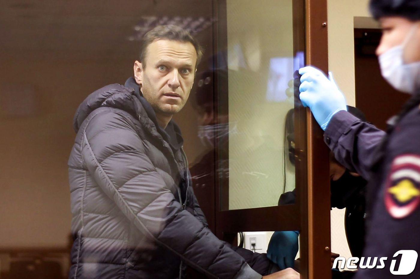 본문 이미지 - 러시아 야당 지도자 알렉세이 나발니가 지난 2020년 6월 2차 대전 참전 퇴역 군인 명예훼손 혐의로 기소된 뒤 법정 심리 중 유리 감방 안에서 바라보고 있다. 2021.02.05/ ⓒ AFP=뉴스1 ⓒ News1 임윤지 기자