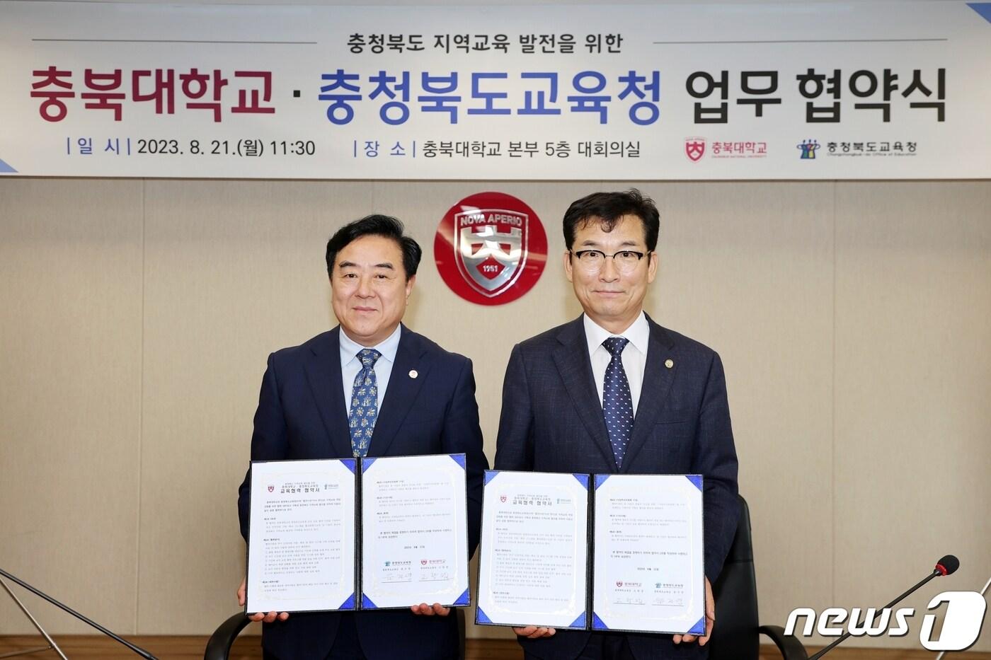 윤건영 충북도교육감&#40;오른쪽&#41;과 고창섭 충북대학교 총장이 21일 충북대 회의실에서 우수 교원 확보를 위한 업무협약서에 서명한 뒤 기념촬영을 하고 있다.&#40;충북교육청 제공&#41;/ 뉴스1