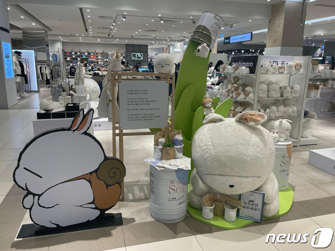 본문 이미지 - 롯데백화점 김포공항점 팝업스토어 입구에 대형 마시마로 인형과 페인트통을 연상시키는 녹색 페인트 조형물이 전시되어 있다.(KCC 제공)