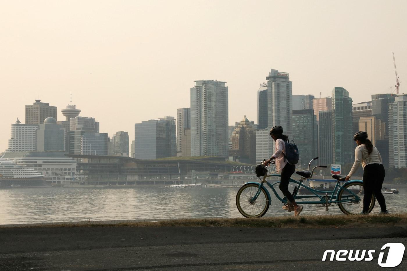 본문 이미지 - 캐나다 벤쿠버에서 시민들이 자전거를 타고 있는 모습. 2023.08.21. ⓒ 로이터=뉴스1