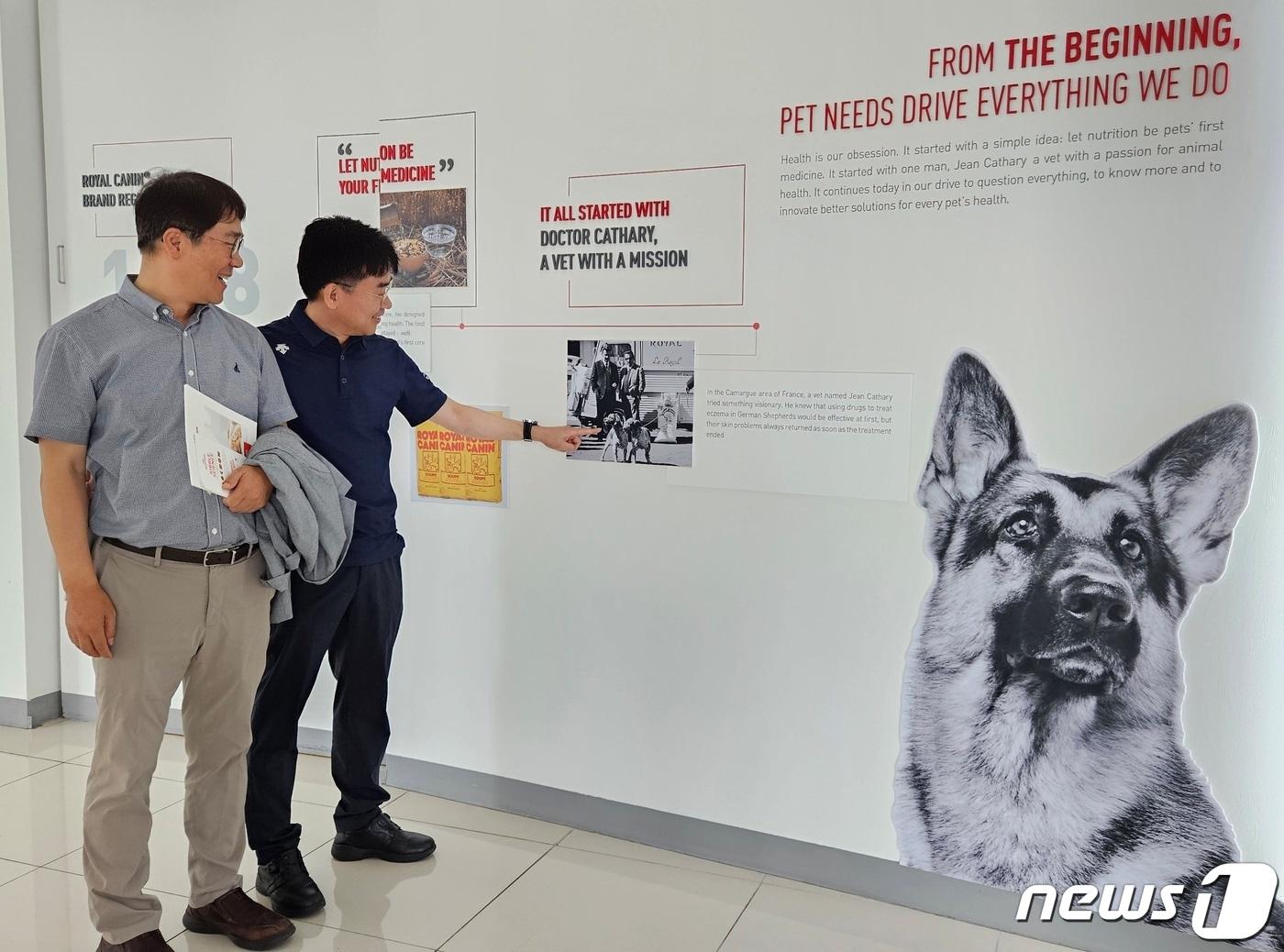 본문 이미지 - 박희명 건국대 교수(왼쪽)와 양철호 한국수의영양학회 회장이 21일 로얄캐닌 김제공장에서 연혁을 보고 있다. ⓒ 뉴스1 최서윤 기자