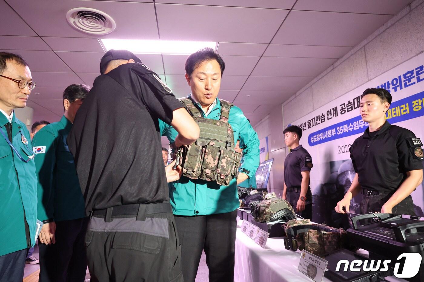 오세훈 서울시장이 23일 서울 중구 시청역에서 열린 ‘을지연습 연계 공습 대비 민방위 훈련’에서 대테러 진압 장비를 착용해보고 있다. (공동취재) 2023.8.23/뉴스1 ⓒ News1 박세연 기자