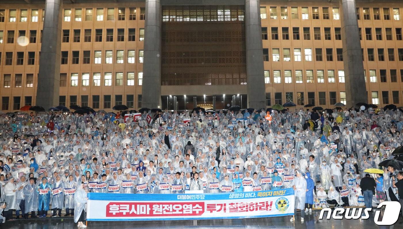 본문 이미지 - 더불어민주당 의원들과 당원들이 23일 밤 서울 여의도 국회 본청 앞 계단에서 열린 후쿠시마 원전오염수 해양투기 철회 촉구 촛불집회에서 구호를 외치고 있다. ⓒ News1 송원영 기자