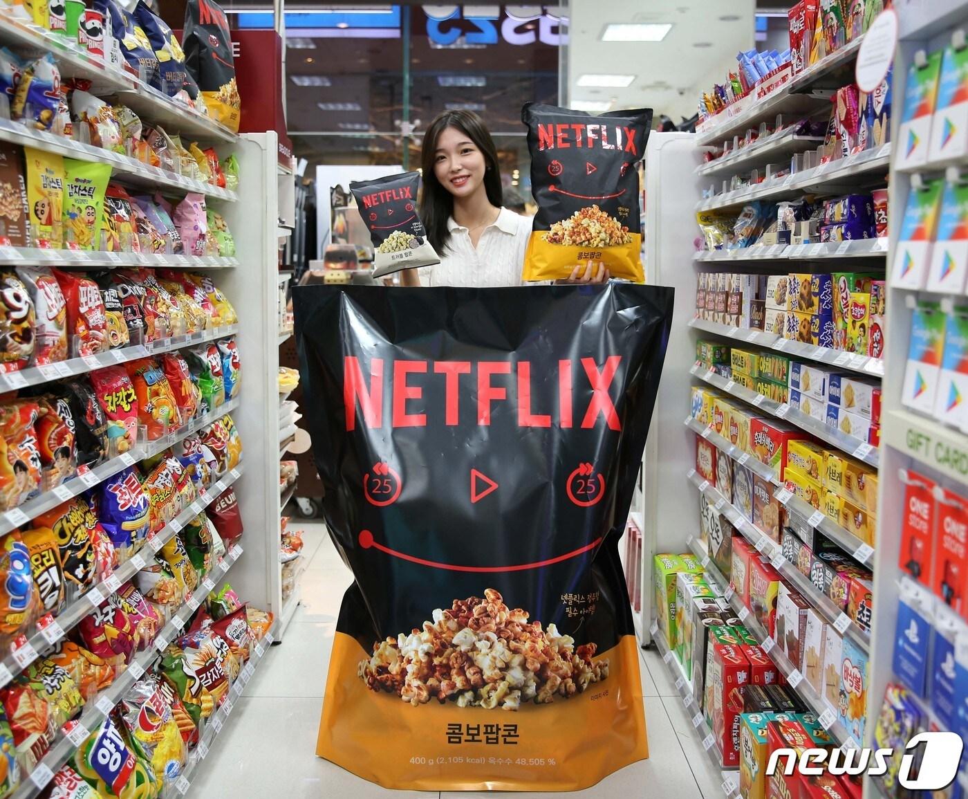 본문 이미지 - 모델이 넷플릭스인간팝콘 뒤에서 넷플릭스트러플팝콘과 넷플릭스점보팝콘을 들고 있다(GS리테일 제공).