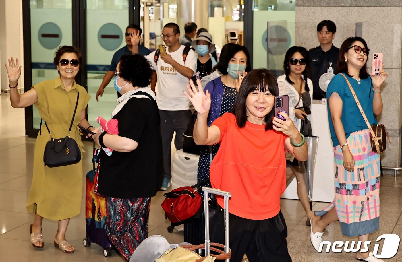 중국인 단체 관광객들이 24일 오후 인천국제공항을 통해 입국하며 손을 흔들어 인사하고 있다. 한국관광공사는 중국 방한 관광시장 정상화에 따른 중국 방한단체 맞이 환대 행사를 열고 이날 입국한 관광객들에게 꽃다발과 기념품을 전달했다. (공동취재) 2023.8.24/뉴스1 ⓒ News1 박정호 기자