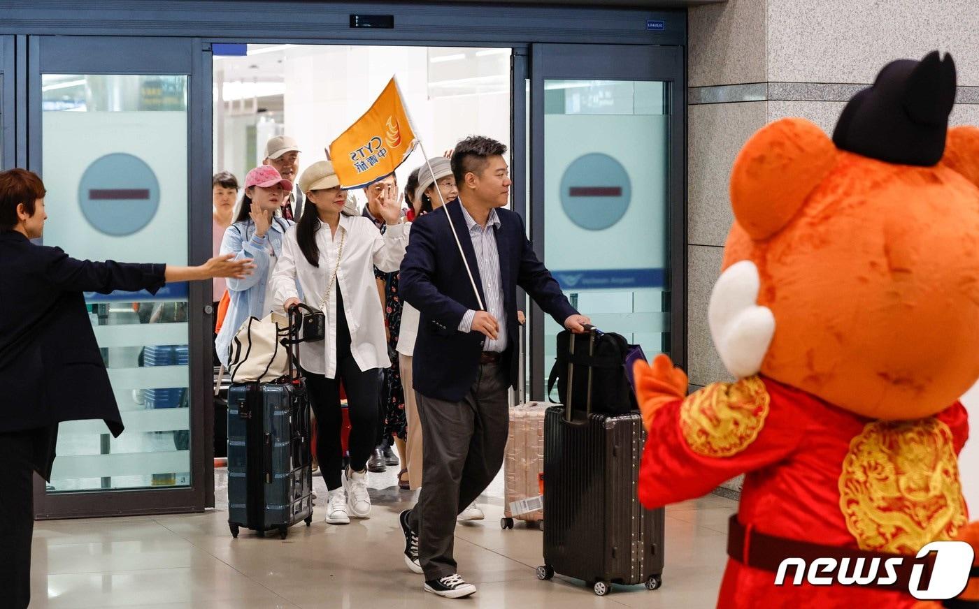 중국인 단체 관광객들이 인천국제공항을 통해 입국하며 손을 흔들어 인사하고 있다. 한국관광공사는중국 방한단체 맞이 환대 행사를 열고 이날 입국한 관광객들에게 꽃다발과 기념품을 전달했다. &#40;공동취재&#41; 2023.8.24/뉴스1 ⓒ News1 박정호 기자