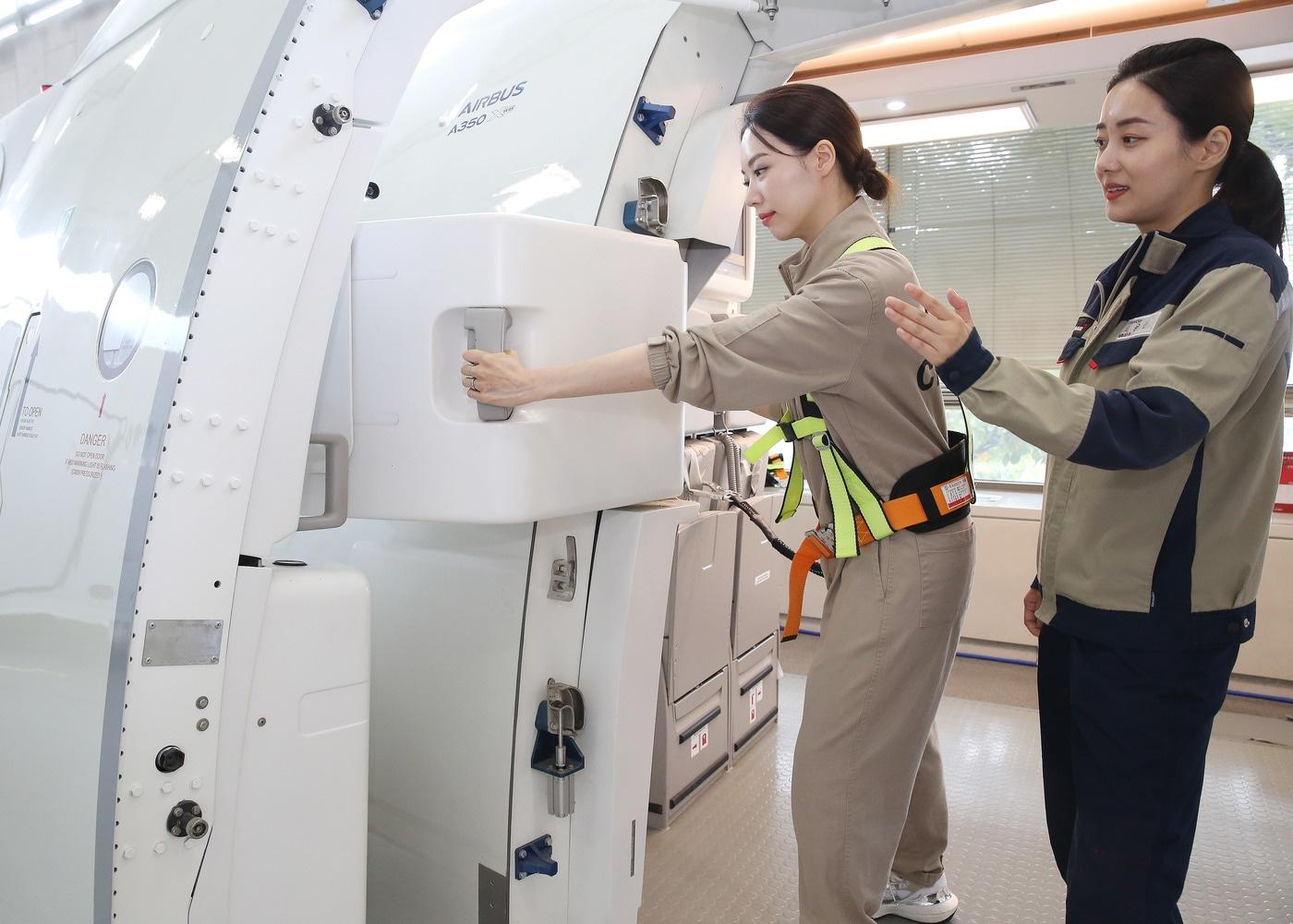 본문 이미지 - 승무원이 비상 탈출훈련 중 출입구를 여는 모습(아시아나항공 제공)