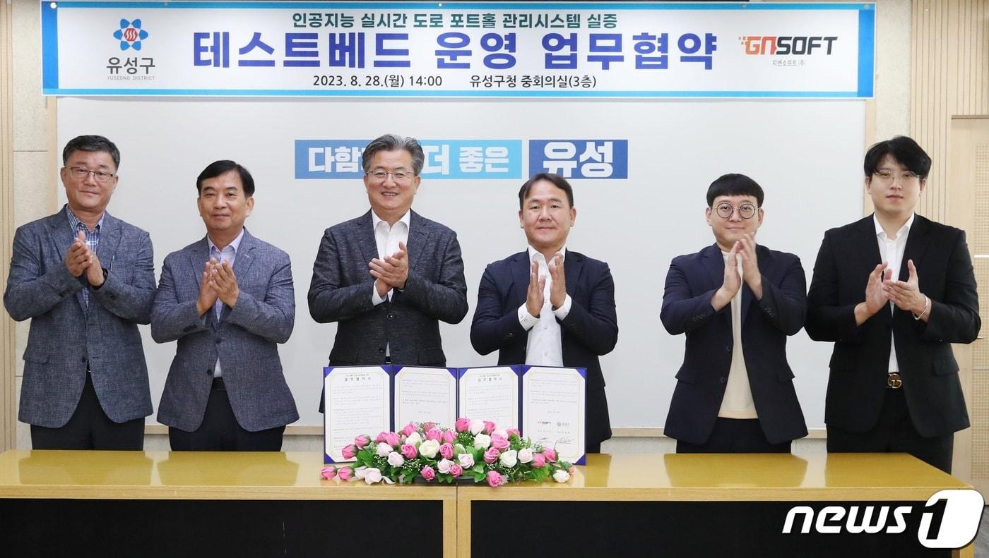 대전 유성구(구청장 정용래, 왼쪽 세 번째)는 28일 구청 중회의실에서 지엔소프트㈜(대표이사 김진수, 〃 네 번째)와 인공지능 실시간 도로 포트홀 관리시스템 실증 테스트베드 운영 업무협약을 맺었다. (유성구 제공) /뉴스1