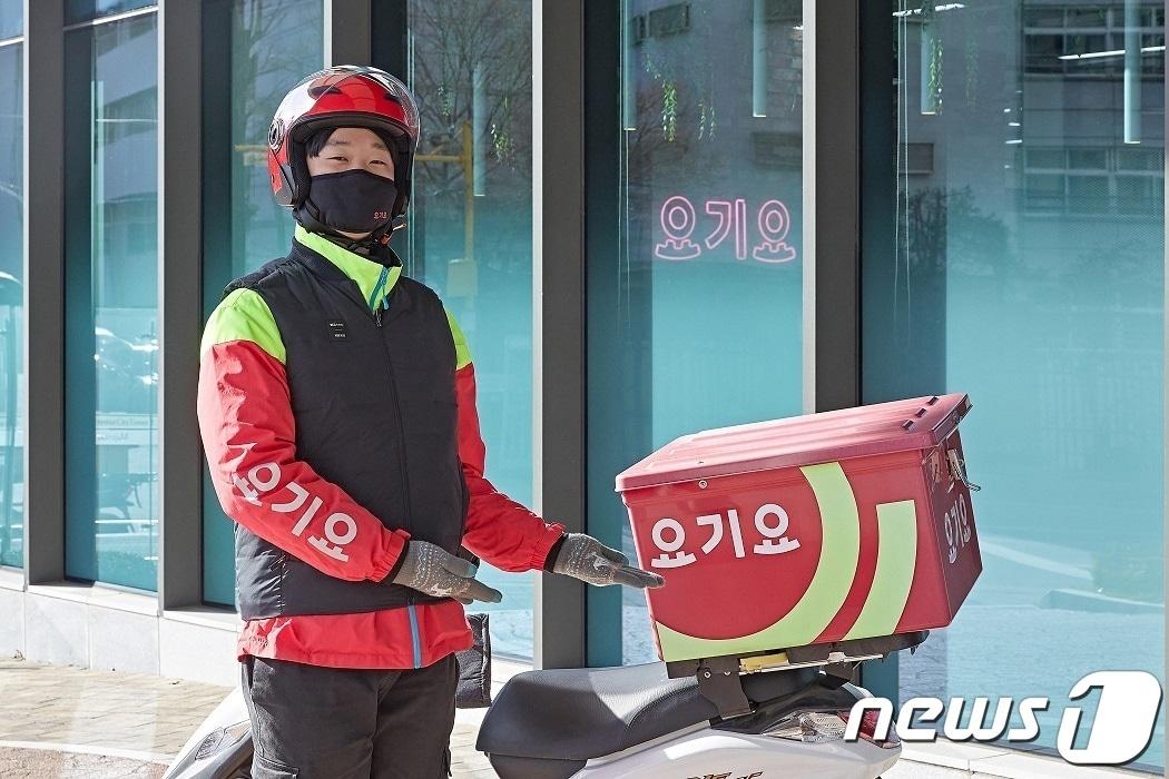 본문 이미지 - 요기요 라이더가 배달 오토바이 앞에 서 있다.(요기요 제공)