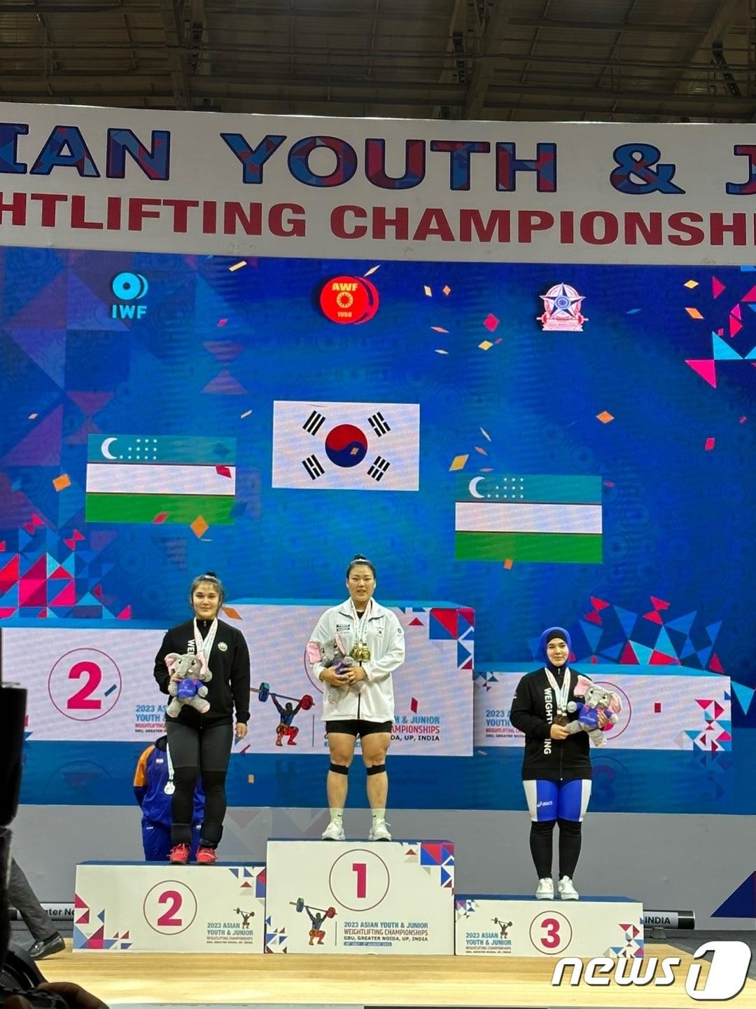 본문 이미지 - 박수민(가운데)이 3일(한국시간) 열린 2023 아시아주니어역도선수권에서 합계 금메달을 차지한 뒤 시상대에서 기념 촬영을 하고 있다. (대한역도연맹 제공)