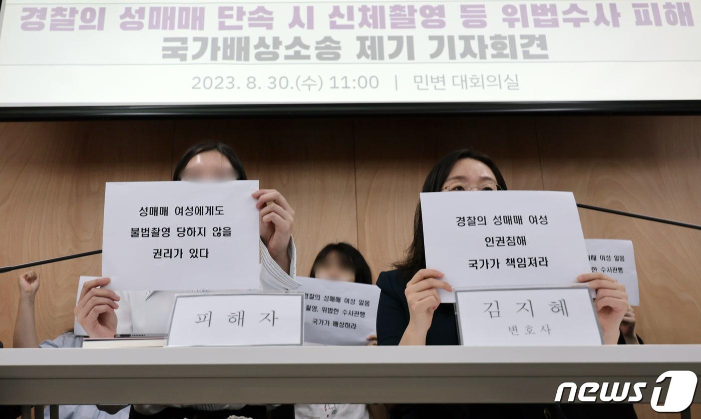 본문 이미지 - 30일 서울 서초구 민주사회를 위한 변호사모임(민변)에서 열린 '경찰의 성매매 단속 시 신체촬영 등 위법수사 피해 국가배상소송 제기 기자회견'에서 피해자와 변호사 등 참석자들이 구호를 외치고 있다.  2023.8.30 ⓒ 뉴스1 안은나 기자
