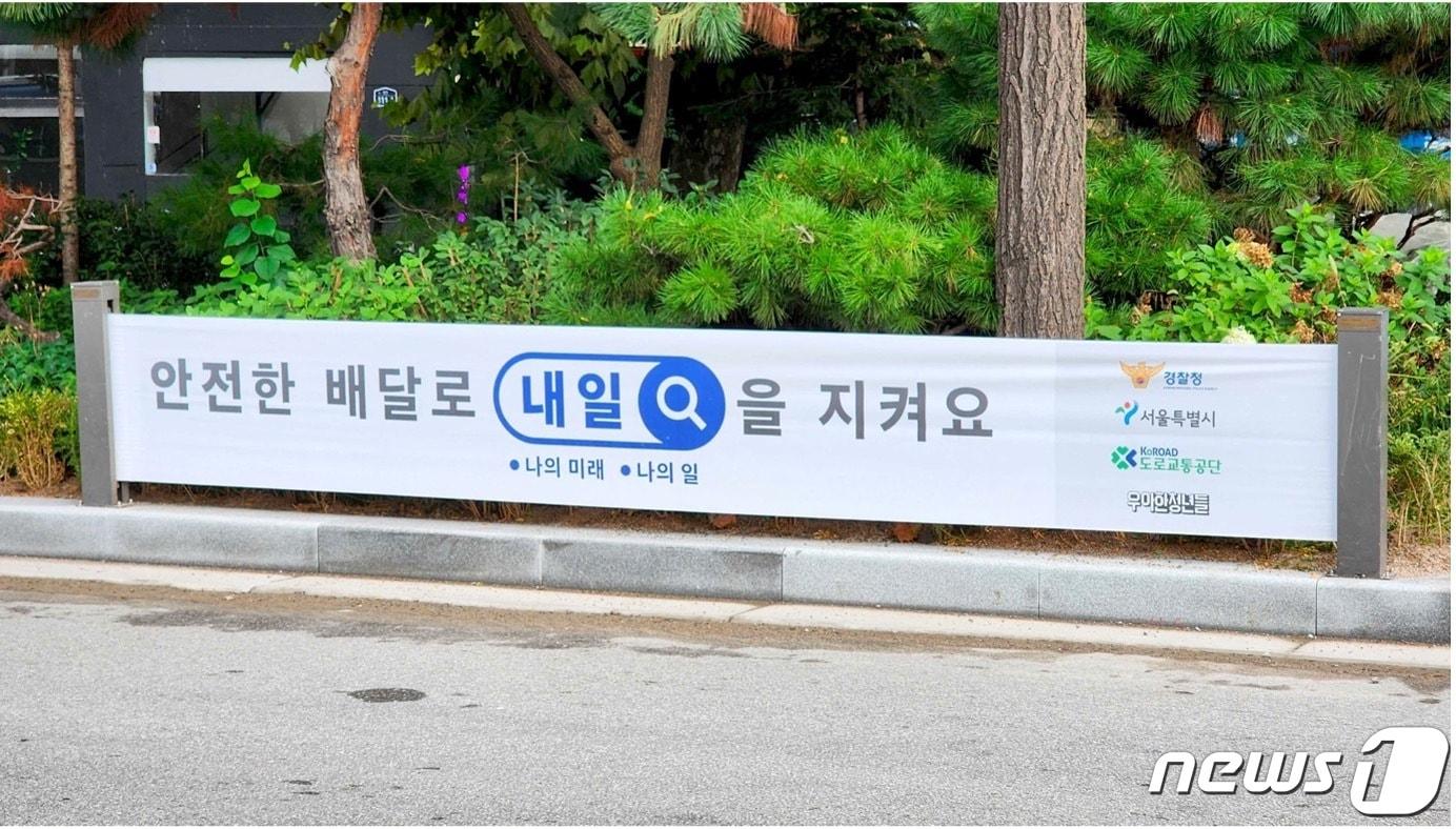 본문 이미지 - 서울 종로구 신설동역 11번 출구 부근 이륜차 사고다발지점에 걸린 안전 배달 당부 현수막 모습(우아한청년들 제공)