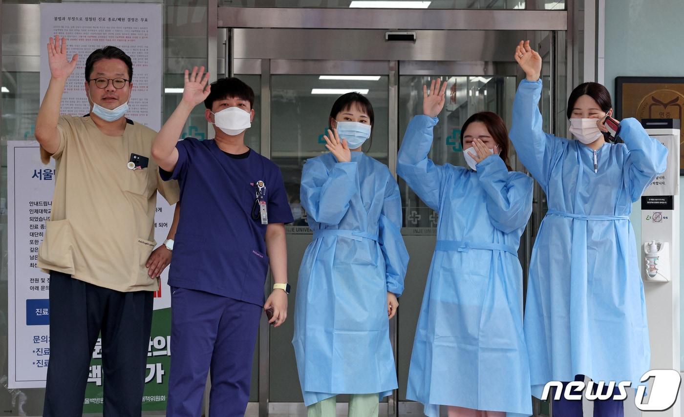 본문 이미지 - 서울백병원 진료 마지막 날인 31일 오후 서울 중구 인제대학교 서울백병원 입구에서 의료진 등 교직원들이 취재진을 향해 손을 흔들고 있다. 1941년 '백인제외과병원'으로 개원한 이후 83년간 진료를 이어온 서울백병원은 이날 오후 5시까지 진료를 마치고 폐원한다. 2023.8.31/뉴스1 ⓒ News1 장수영 기자