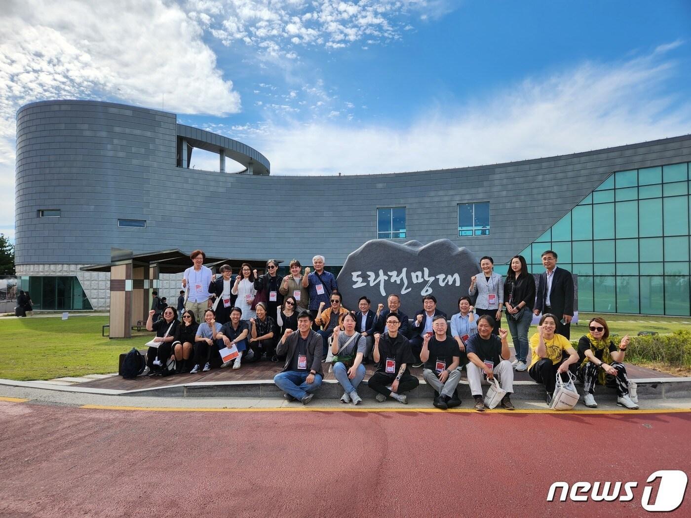 본문 이미지 - 31일 파주 도라전망대에서 개막된 ‘DMZ 전시 : 체크포인트’의 큐레이터와 참여 작가들. (경기관광공사 제공)