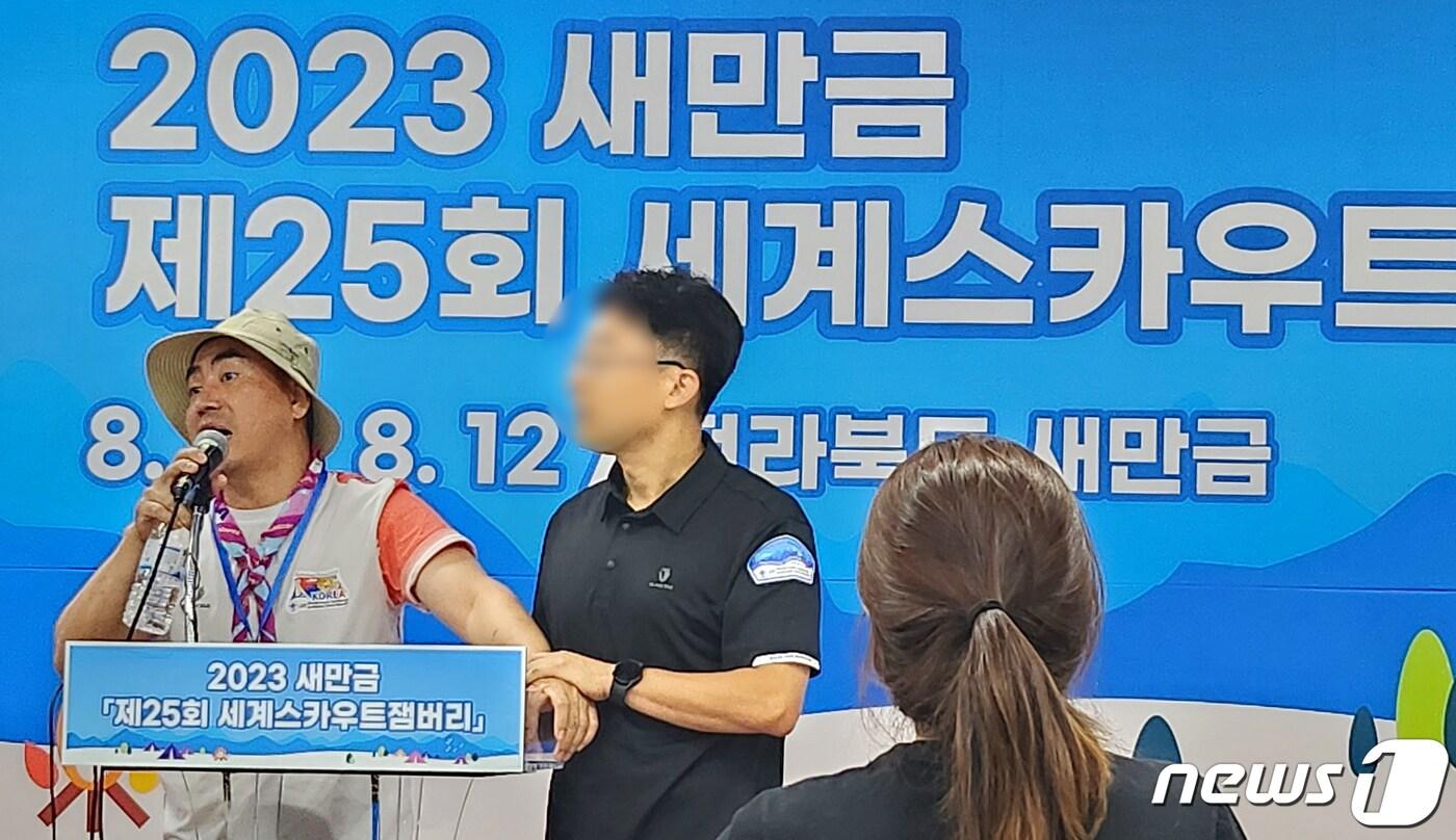 본문 이미지 - 6일 전북 부안군 세계스카우트잼버리 프레스센터에서 한국스카우트 전북연맹 비마이프렌드 관계자가 긴급 기자회견 중 잼버리 조직위 관계자에게 제지를 받고 있다. 이 관계자들은 잼버리 영지 내 성범죄 사건 발생과 관련해 퇴소하겠다고 밝히고 있다. ⓒ News1 유경석 기자