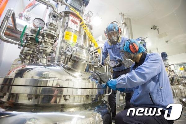 본문 이미지 - 에스티팜 연구원들이 바이오리액터를 점검하고 있다./에스티팜 제공