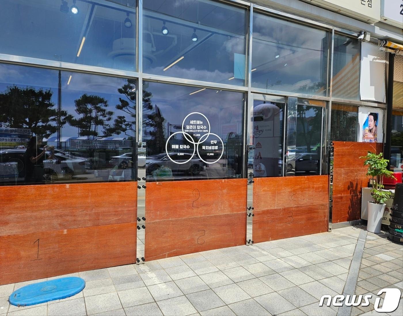 본문 이미지 - 부산 서구 송도해수욕장의 한 식당에 바닷물을 막기 위해 설치된 합판. 2023.8.8/뉴스1 ⓒ News1 권영지 기자