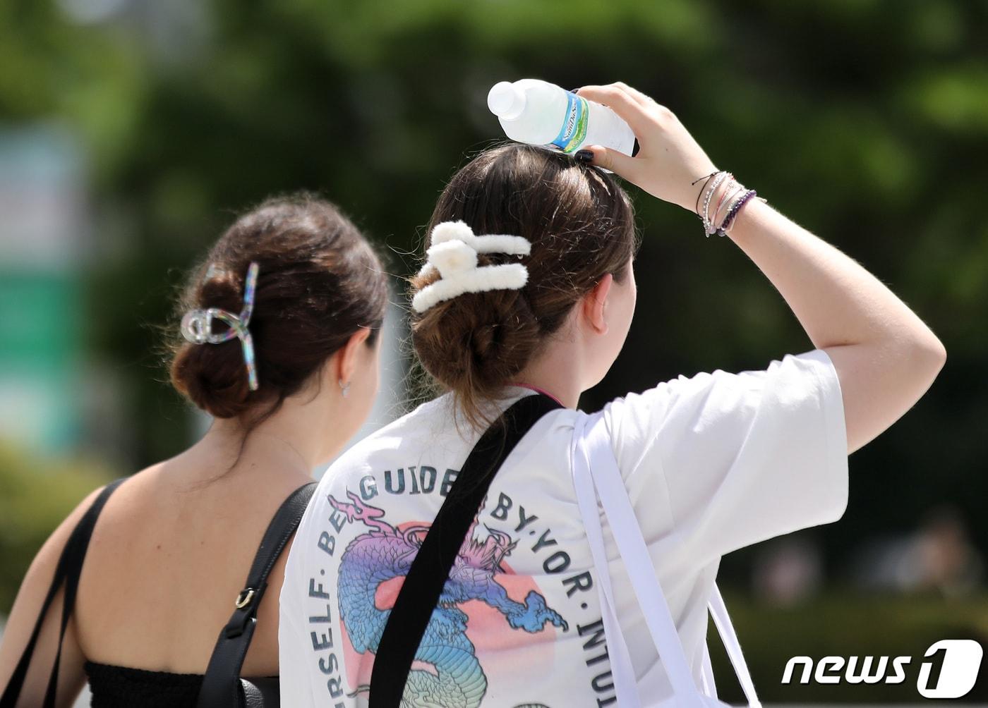 본문 이미지 - 절기상 입추(立秋)인 8일 오후 서울 서대문구 이화여대에서 한 외국인 유학생이 차가운 물병으로 머리를 식히며 걷고 있다. 2023.8.8/뉴스1 ⓒ News1 구윤성 기자