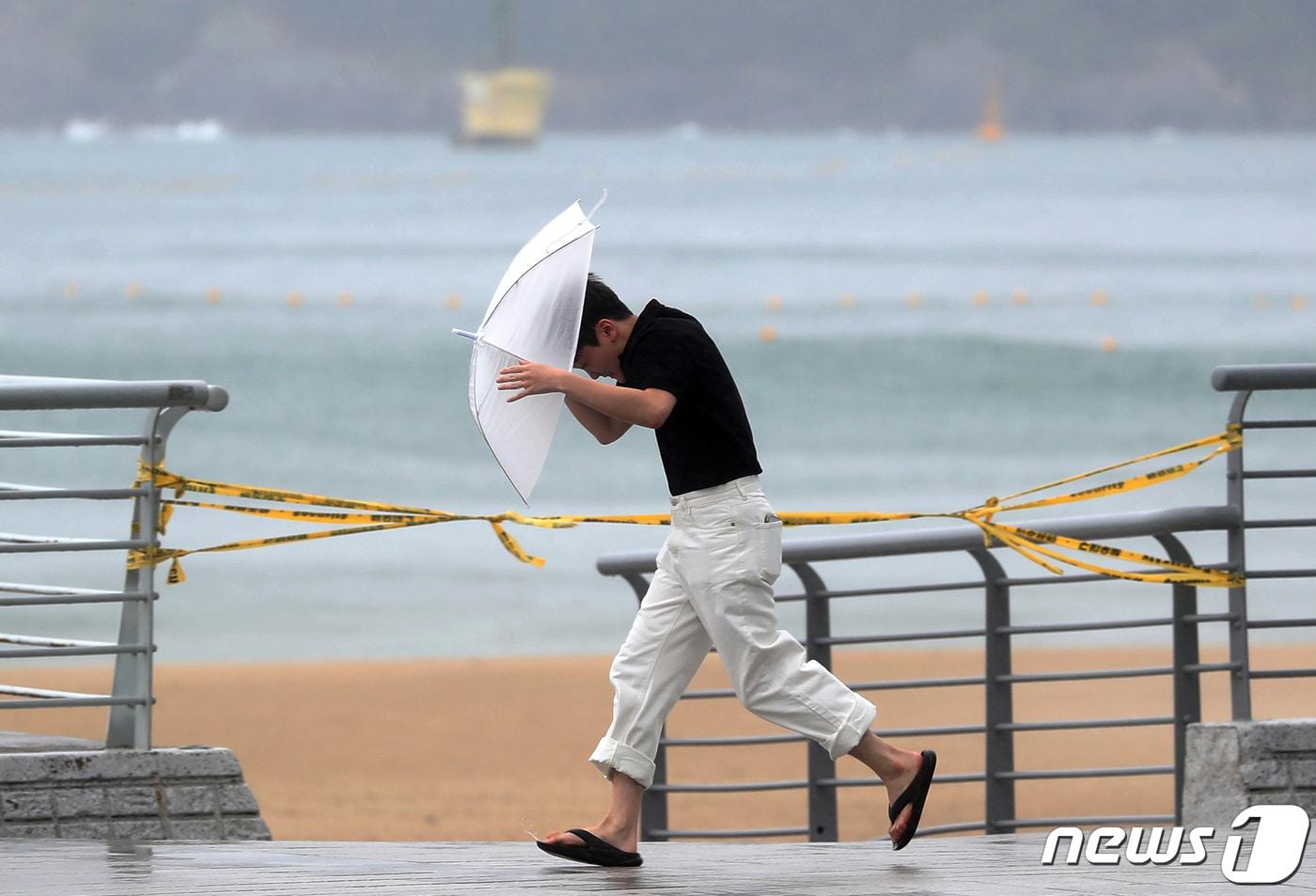 본문 이미지 - 제6호 태풍 '카눈'이 북상 중인 9일 부산 해운대구 엘시티 인근에 강한 빌딩풍이 몰아쳐 한 시민이 우산을 부여 잡고 힘겹게 걷고 있다. 2023.8.9/뉴스1 ⓒ News1 윤일지 기자