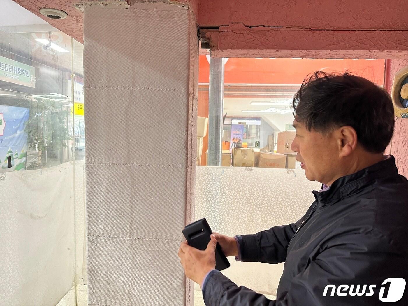 본문 이미지 - 11일 충북 충주시가 중앙어울림시장 정밀안전진단 결과가 D등급이 나왔다며 철거를 추진할 수 밖에 없다고 밝혔다. 사진은 크랙이 발생한 1층 기둥을 살펴보고 있는 정경모 상인회장./뉴스1 ⓒ News1 윤원진 기자