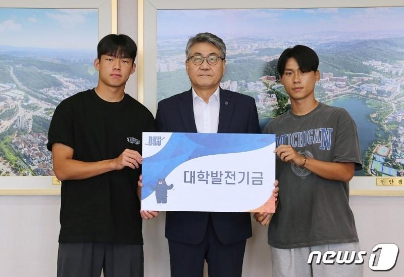 본문 이미지 - 12일 안순철 단국대 총장(가운데)이 단국대 축구부 박승호군(왼쪽)과 박준배군으로부터 발전기금을 전달받은 뒤 기념촬영하고 있다.(단국대 제공)