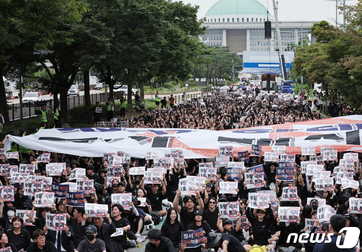 전국 교사들이 지난달 16일 오후 서울 여의도 국회의사당 앞에서 열린 '9.16 공교육 회복을 위한 국회 입법 촉구 집회'에서 국회를 향해 교권 회복을 촉구하는 현수막 파도타기를 하고 있다. /뉴스1 ⓒ News1 장수영 기자