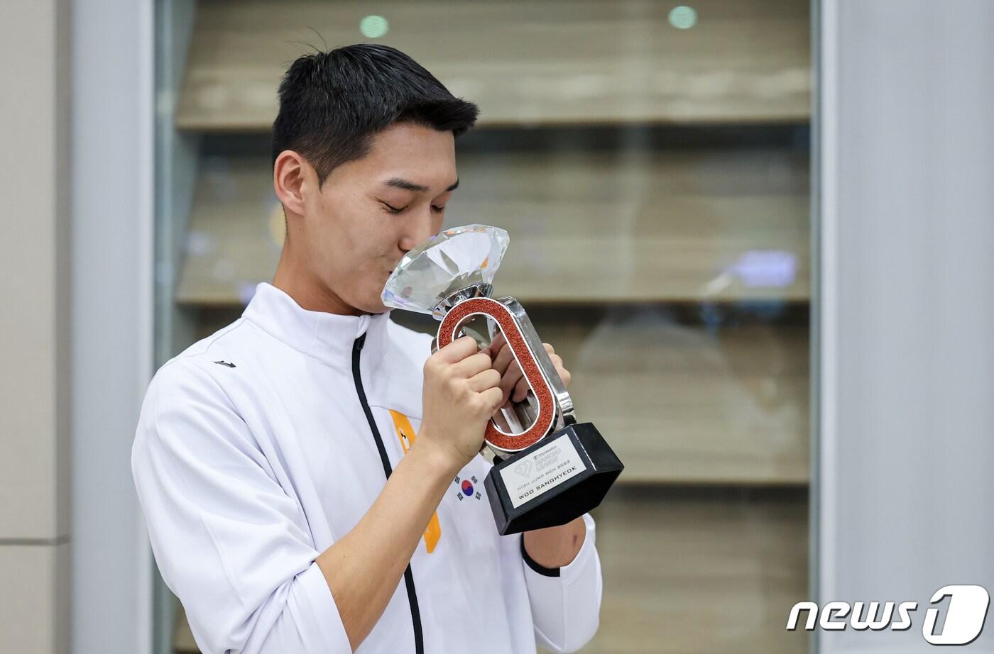 한국 최초로 세계육상연맹 다이아몬드리그 우승을 차지한 우상혁이 19일 오후 인천국제공항 제2여객터미널을 통해 귀국해 트로피에 입을 맞추고 있다.  2023.9.19/뉴스1 ⓒ News1 김도우 기자