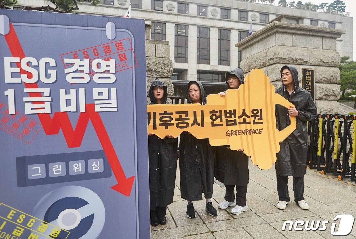 헌법재판소 앞에서 그린피스 활동가들이 &#39;기후공시 도입&#39;을 촉구하는 퍼포먼스를 하고 있다.&#40;그린피스 제공&#41; ⓒ 뉴스1