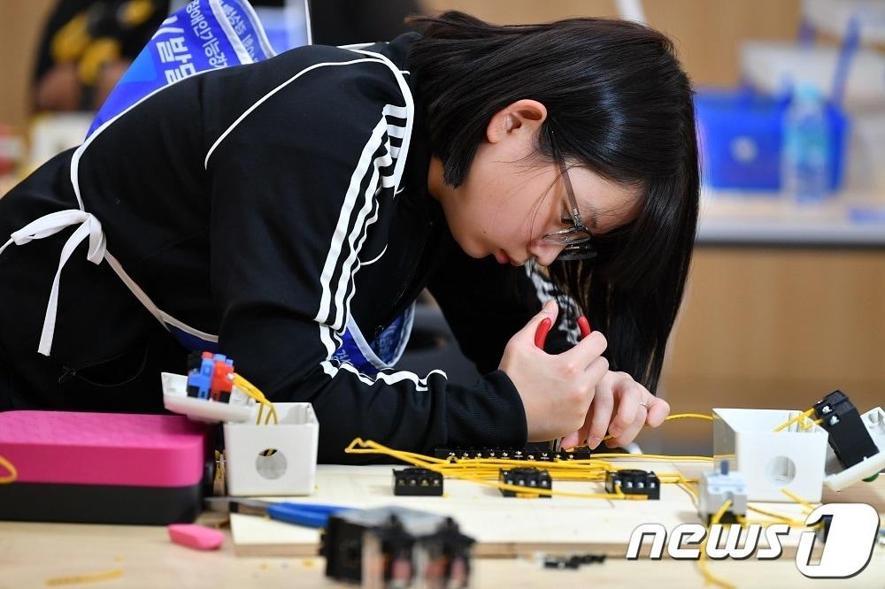 본문 이미지 - 2023년 제40회 전국장애인기능경기대회에서 기기조립 직종(발달)에 출전한 선수가 집중하며 기기를 만지고 있다. (전국장애인기능경기대회 조직위 제공) 