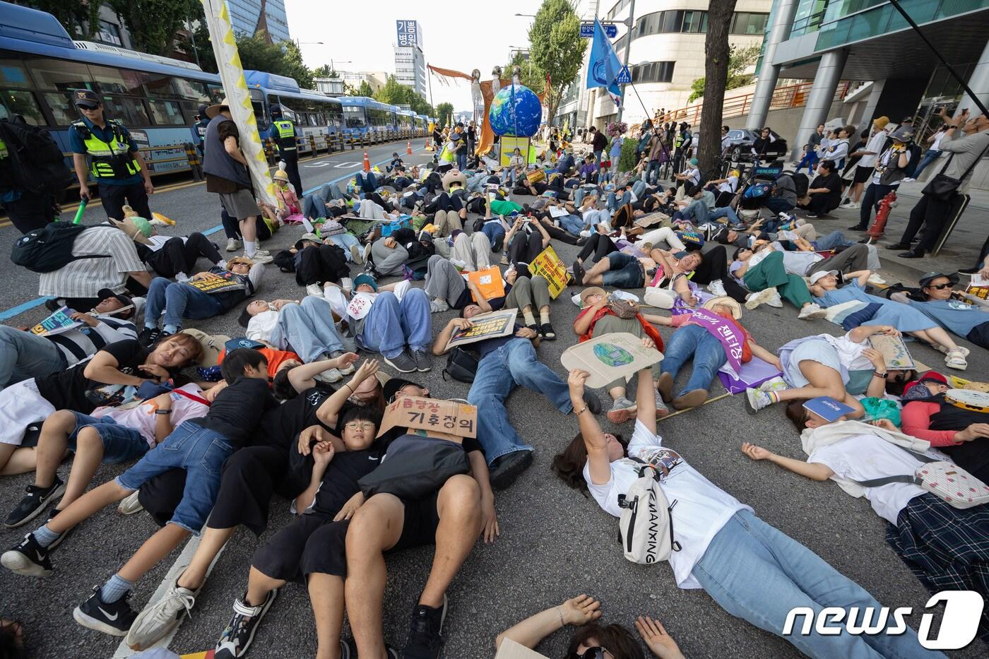 본문 이미지 - 23일 오후 서울 중구 서울시청역 인근에서 열린 9·23 기후정의행진에서 참가자들이 대통령실 방향으로 행진하는 도중 바닥에 눕는 퍼포먼스를 하고 있다. 2023.9.23/뉴스1 ⓒ News1 이재명 기자