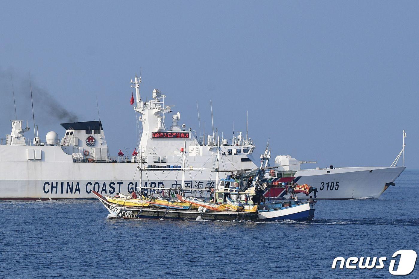 지난 20일&#40;현지시간&#41; 남중국해&#40;서필리핀해&#41; 스카버러 암초&#40;중국명 황옌다오·필리핀명 바조데마신록&#41; 인근에서 조업하는 필리핀 어선 옆으로 중국 해안경비대 함정이 지나가고 있다. 2023.9.25. ⓒ AFP=뉴스1 ⓒ News1 김기성 기자