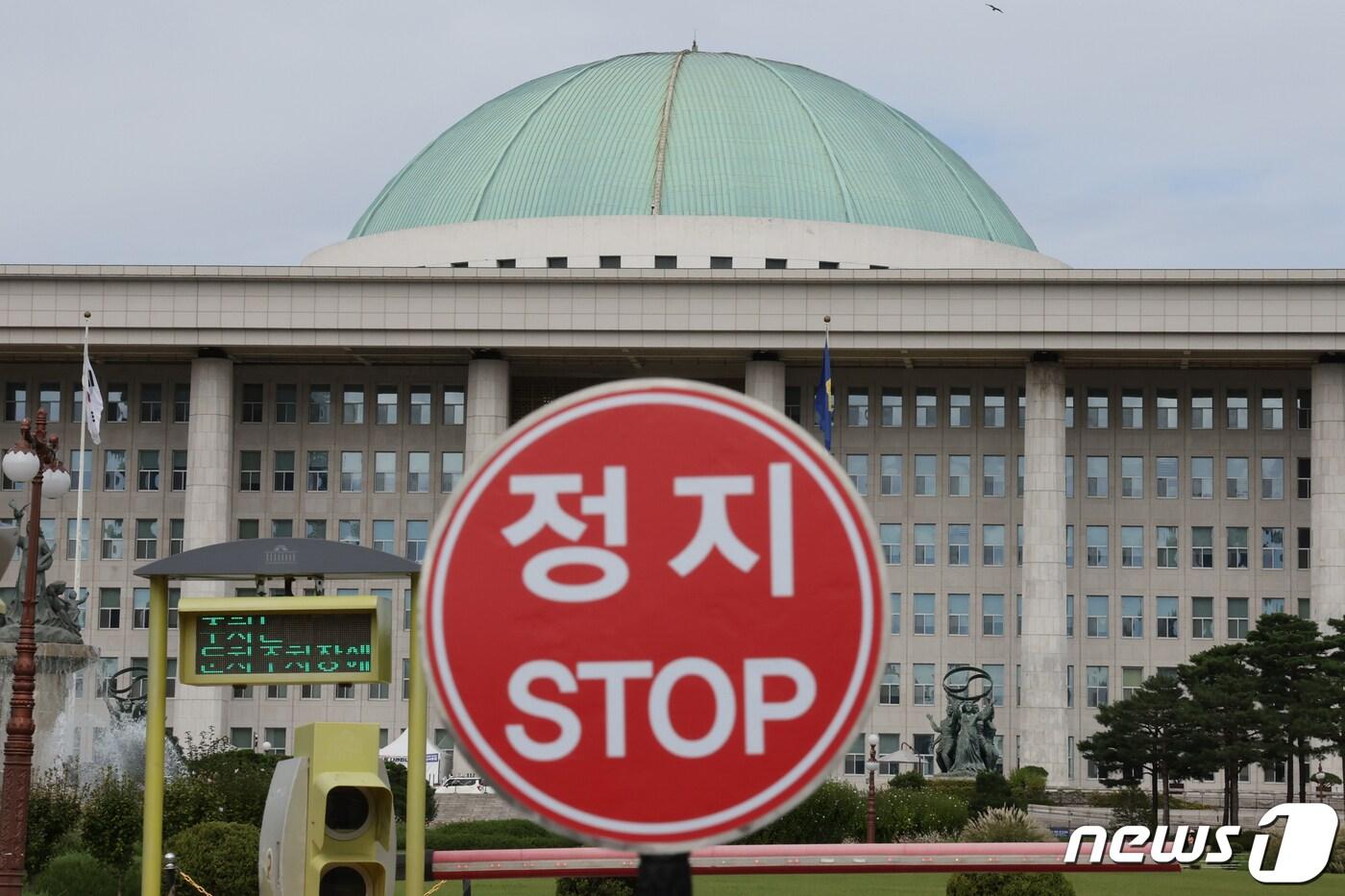 본문 이미지 - 제1야당 당대표 체포동의안 가결부터 국회의 국무총리 해임 건의에 이르기까지 사상 초유의 상황이 반복되면서 정국이 꽁꽁 얼어붙은 가운데 25일 정지 표지판 너머로 서울 여의도 국회의사당이 보이고 있다. 2023.9.25/뉴스1 ⓒ News1 송원영 기자