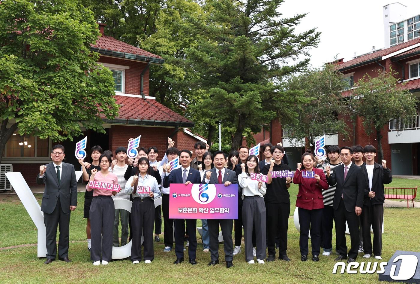 본문 이미지 - 원희룡 국토교통부 장관과 박민식 국가보훈부 장관이 25일 오후 서울 용산공원에서 보훈문화 확산과 국가보훈대상자에 대한 예우·복지 등 지원 강화를 위한 업무협약을 체결한 뒤 호우회 대학생, 국토부 청년정책자문단 등 청년들과 함께 기념촬영을 하고 있다. 이번 업무협약을 통해 두 부처는 먼저 용산공원 내 호국보훈공간 조성 등 보훈을 주제로 한 공간 조성에 협력하기로 했다. 2023.9.25/뉴스1 ⓒ News1 구윤성 기자