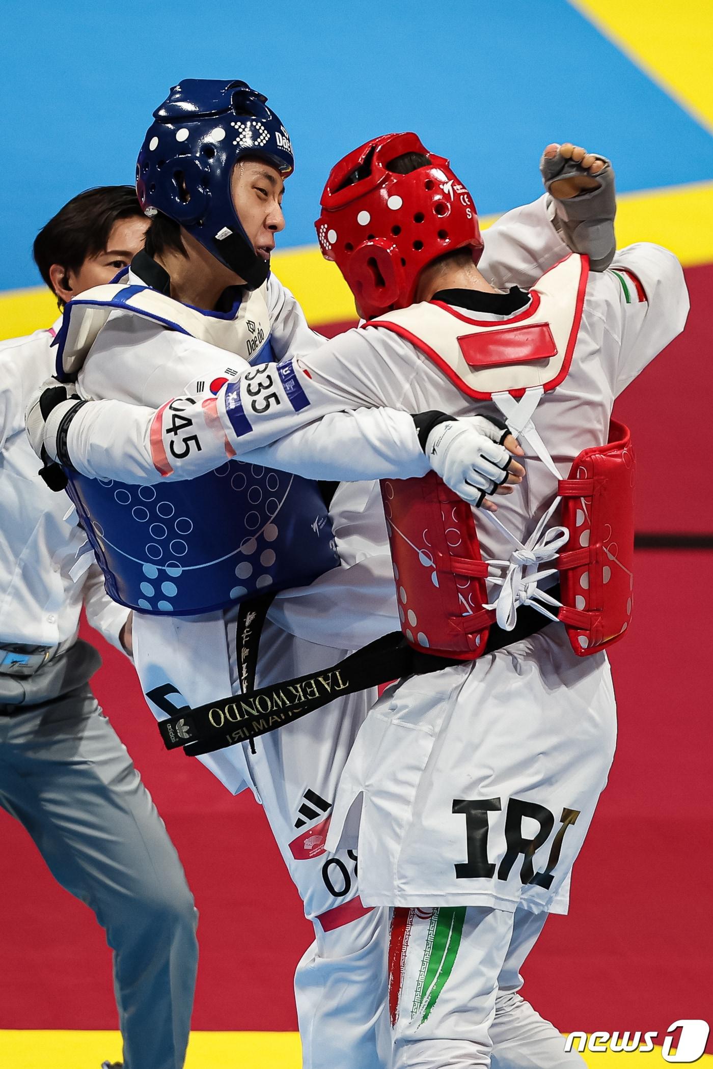 본문 이미지 - 장준이 25일 중국 항저우 린안 스포츠문화·전시센터에서 열린 2022 항저우 아시안게임 태권도 겨루기 남자 58kg급 결승 이란 마흐디와 경기를 펼치고 있다. 장준은 이란 마흐디를 2대0으로 꺾고 금메달을 획득했다. 2023.9.25/뉴스1 ⓒ News1 유승관 기자