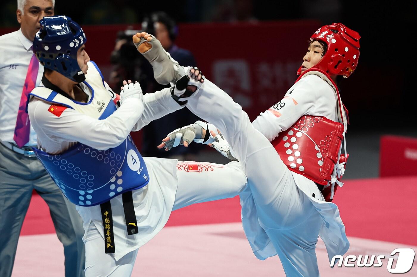 박우혁(오른쪽)이 25일 중국 항저우 린안 스포츠문화·전시센터에서 열린 2022 항저우 아시안게임 태권도 겨루기 혼성 단체전 결승 중국과 경기를 펼치고 있다. 2023.9.25/뉴스1 ⓒ News1 유승관 기자