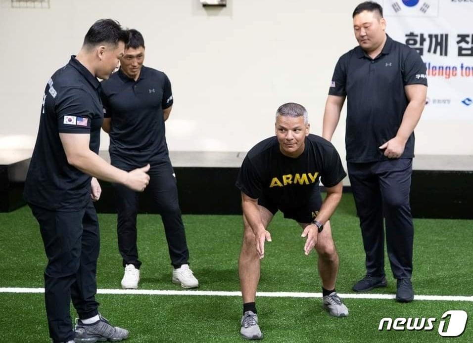 본문 이미지 - 구미시청 씨름단 정창진 감독과 안해용 태백장사, 차승진 백두장사가(왼쪽부터) 캠프캐롤 주임원사에게 씨름의 자세를 가르치고 있다. (씨름진흥원 제공) 2023.9.28/뉴스1