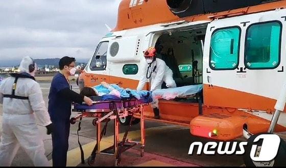 본문 이미지 - 제주대병원 관계자와 소방대원들이 조기출산 위험에 처한 임신부를 소방헬기로 이송하고 있다.(제주소방안전본부 제공)